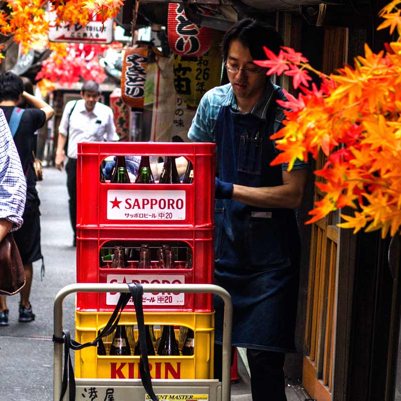 Cervezas del Japón: Repartidor de cervezas Kirin y Sapporo a la puerta de un izakaya en un yokocho